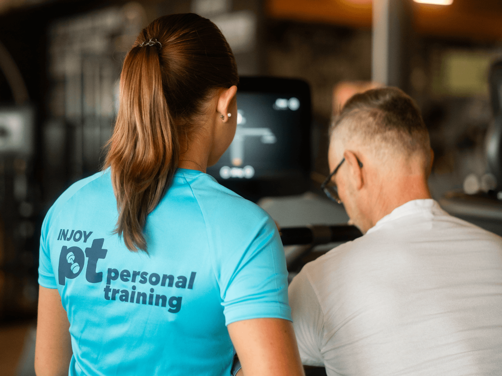 Einführung in das Personal Training von einer Trainerin, die sich um ihren Kunden kümmert.