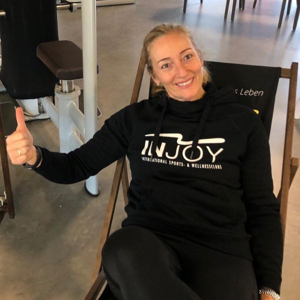 INJOY Inhaberin posiert mit Daumen nach oben