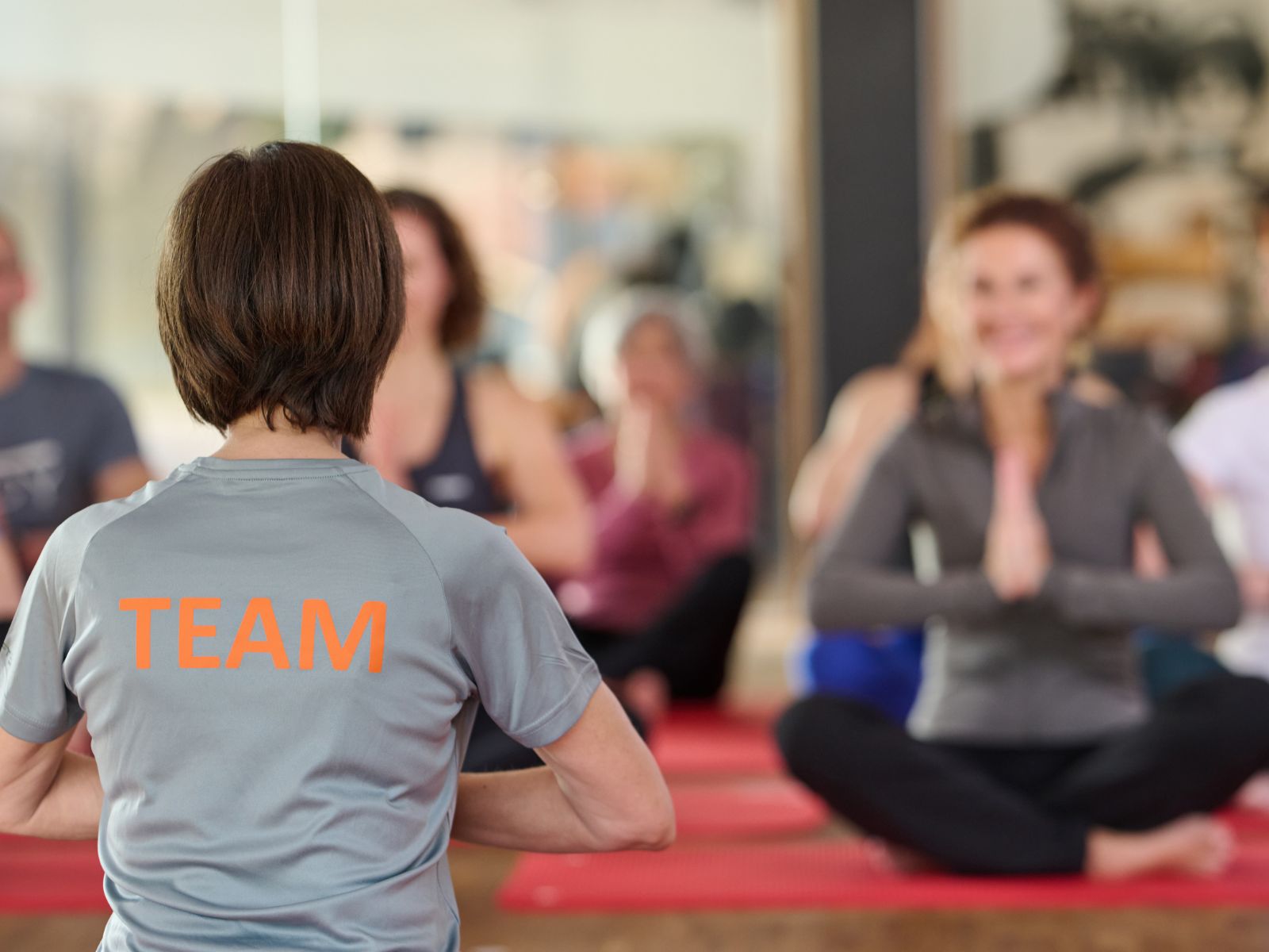 Personen in der Yoga-Position mit gefaltenen Händen im Schneidersitz